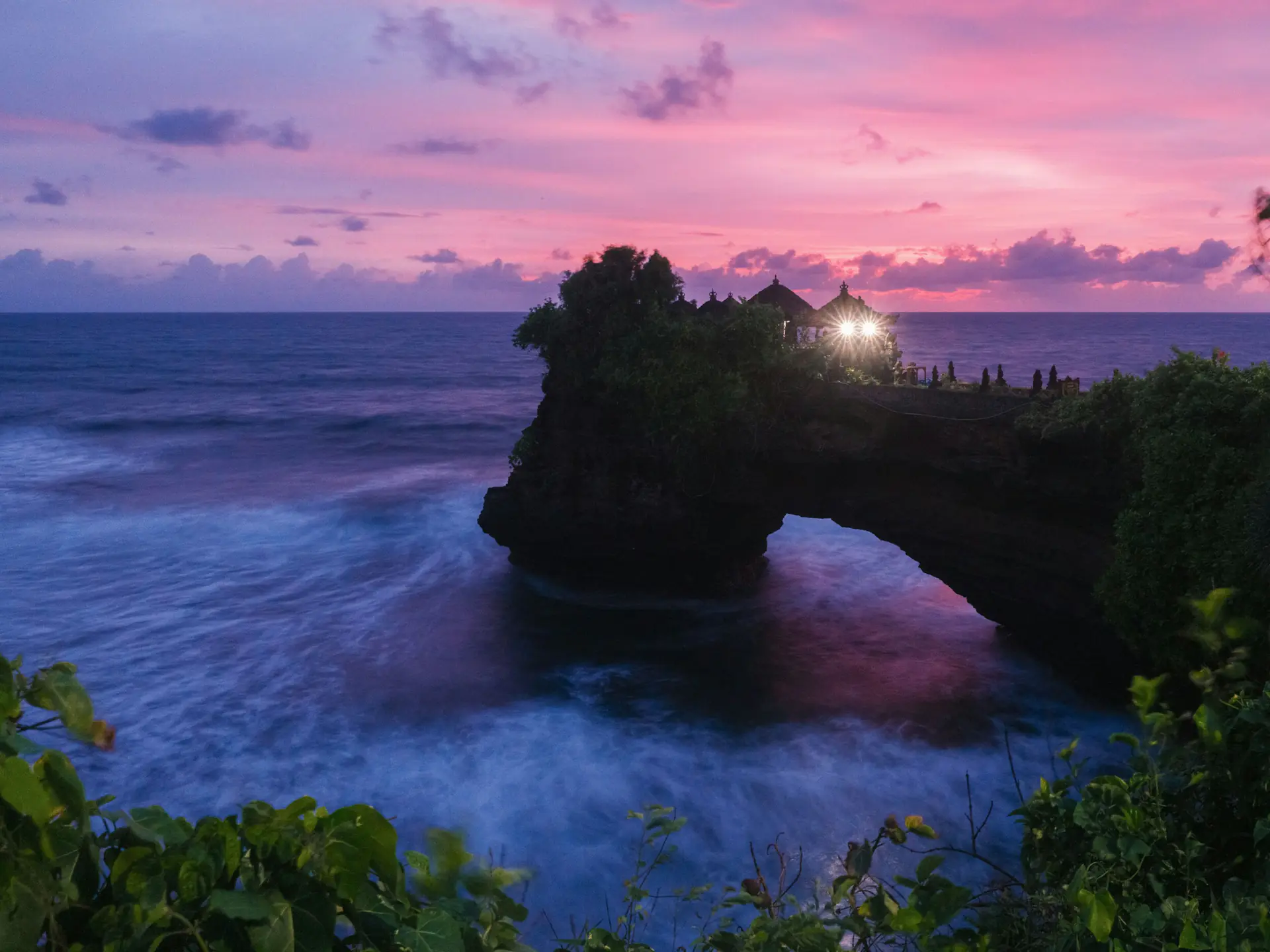 Sunset over the rock arch near Tanah Lot