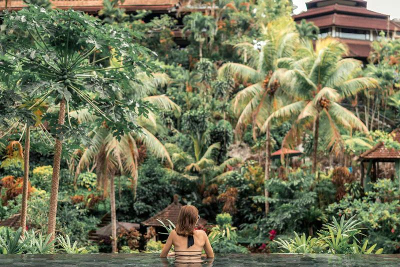 Guest in an infinity pool overlooking the jungle